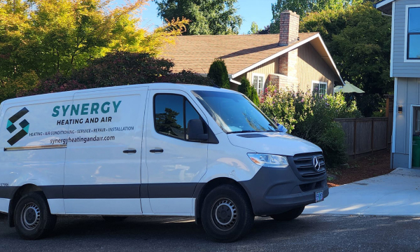 White van with company logo in front of houses
